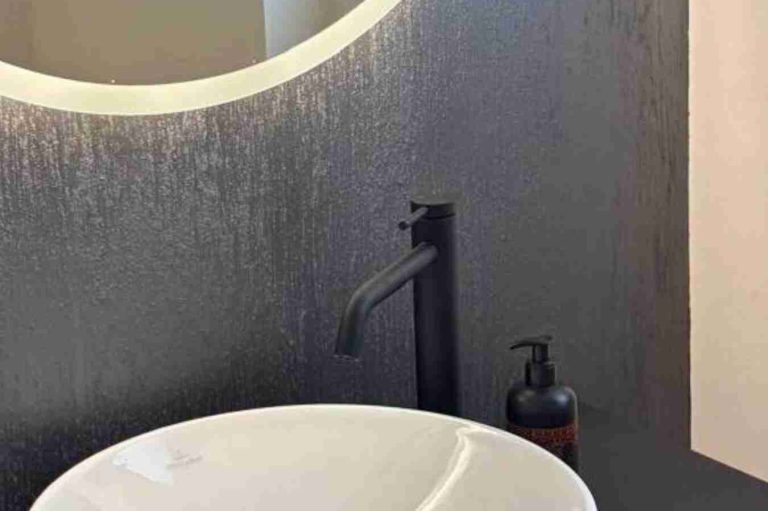 Moderne Wandgestaltung im Gästebad Modernes Waschbecken mit schwarzem Wasserhahn und Seifenspender. Wand gestrichen mit besonderer Farbe in grau.