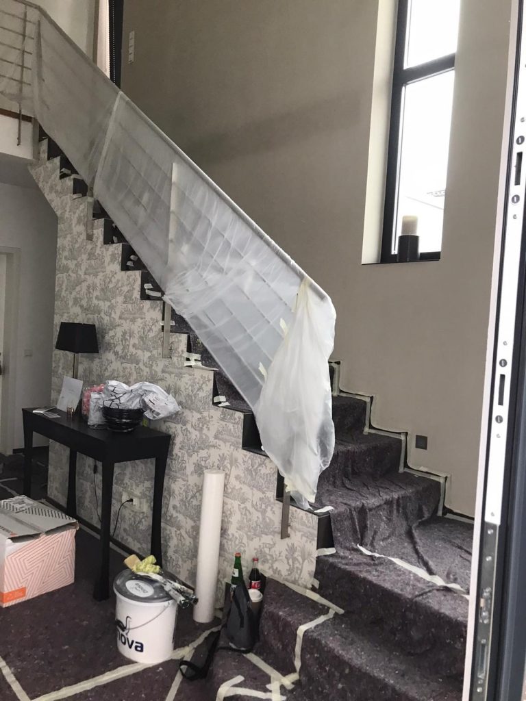 Treppenerneuerung in Kölner Haus Treppenaufgang eines Wohnhauses,der gerade renoviert wird. Das Geländer ist noch abgeklebt, Stufen sauber für die Malerarbeiten abgedeckt.