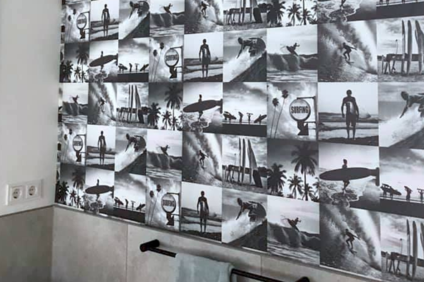 Tapete im Gästebad in Köln. Schwarz-weiße Fotocollage als Tapete mit Surfszenen an einer Wand im Gästebad.