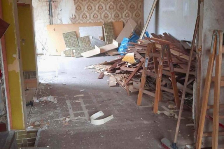 Brandschaden Baustelle Innenraum mit Holzstapel und Bauabfällen auf dem Boden. Baustelle nach einem Brandschaden